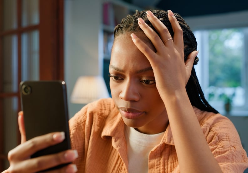 Woman searching breast cancer facts on her phone, looking confused or worried about breast cancer myths
