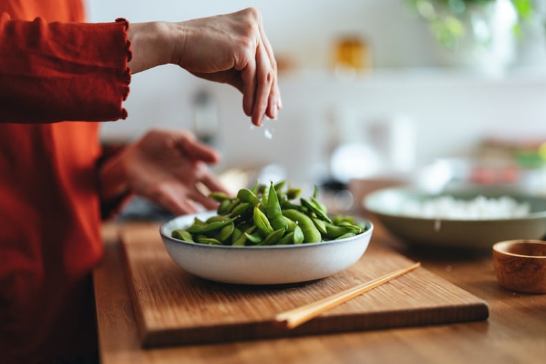 Woman preparing edamame as a veggie snack.