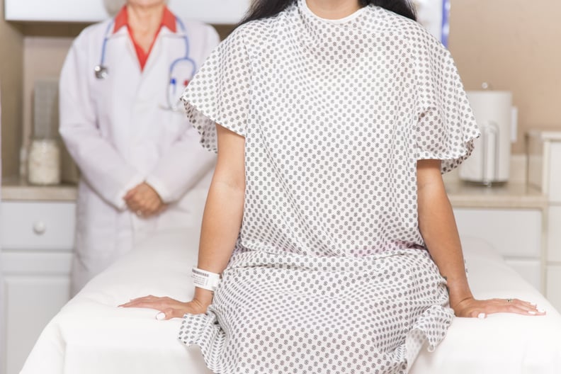 Mid-adult, latin descent woman prepares for her annual breast exam, mammogram from her gynocologist doctor at hospital or clinic.  Or woman wearing hospital gown prepares for medical procedure.  Senior adult, female doctor.  Women's health, issues.  Breas