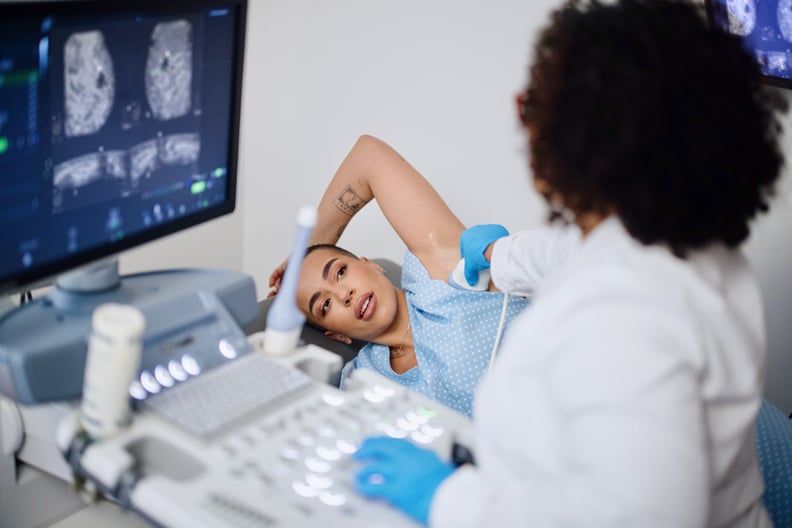 A young woman is doing a breast ultrasound for preventive breast cancer care.